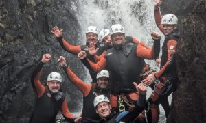 A happy group posing together after a canyoning adventure in Galloway