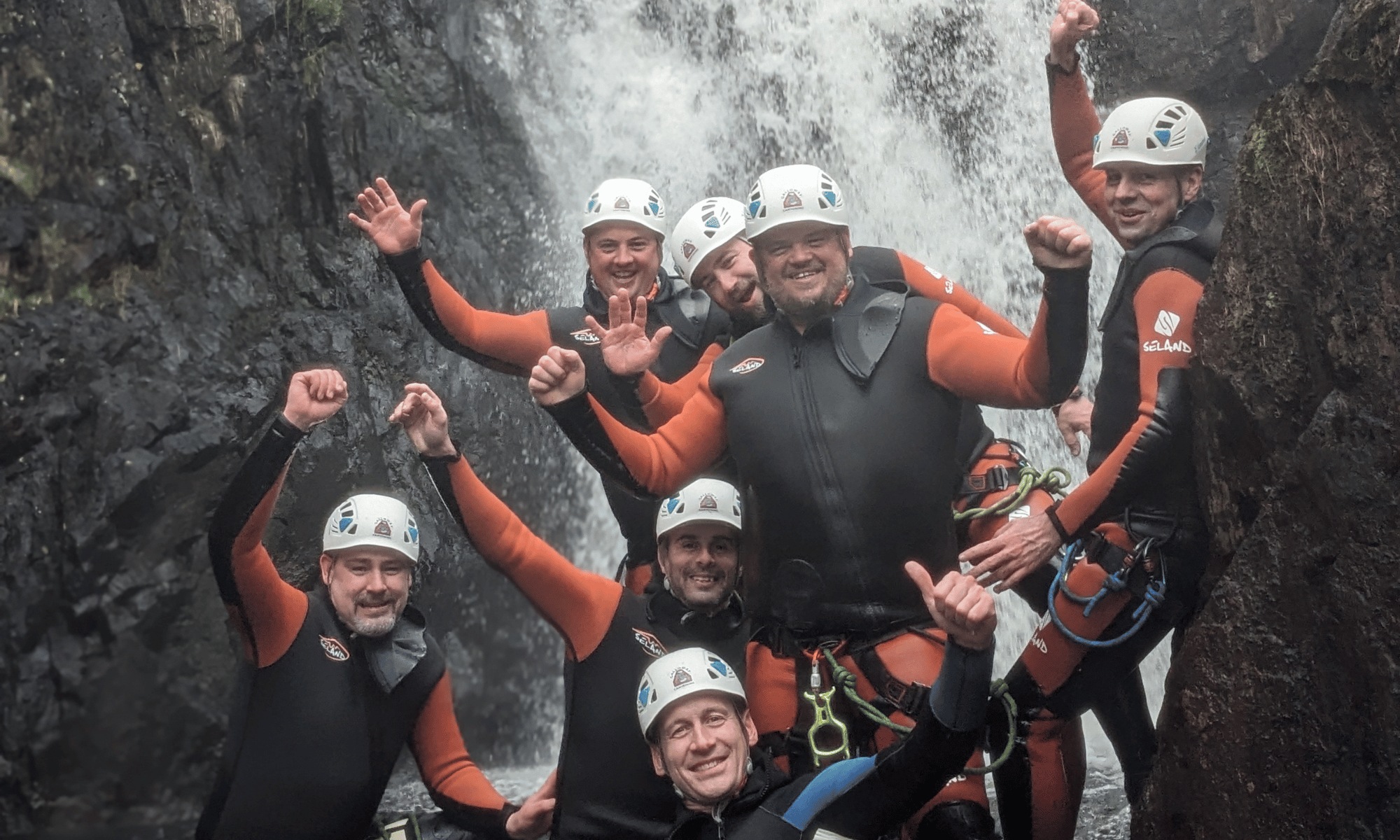 A happy group posing together after a canyoning adventure in Galloway